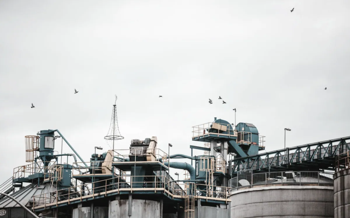 Site industriel de transformation aux installations réparties, évoquant des unités de production conduites selon un même modèle