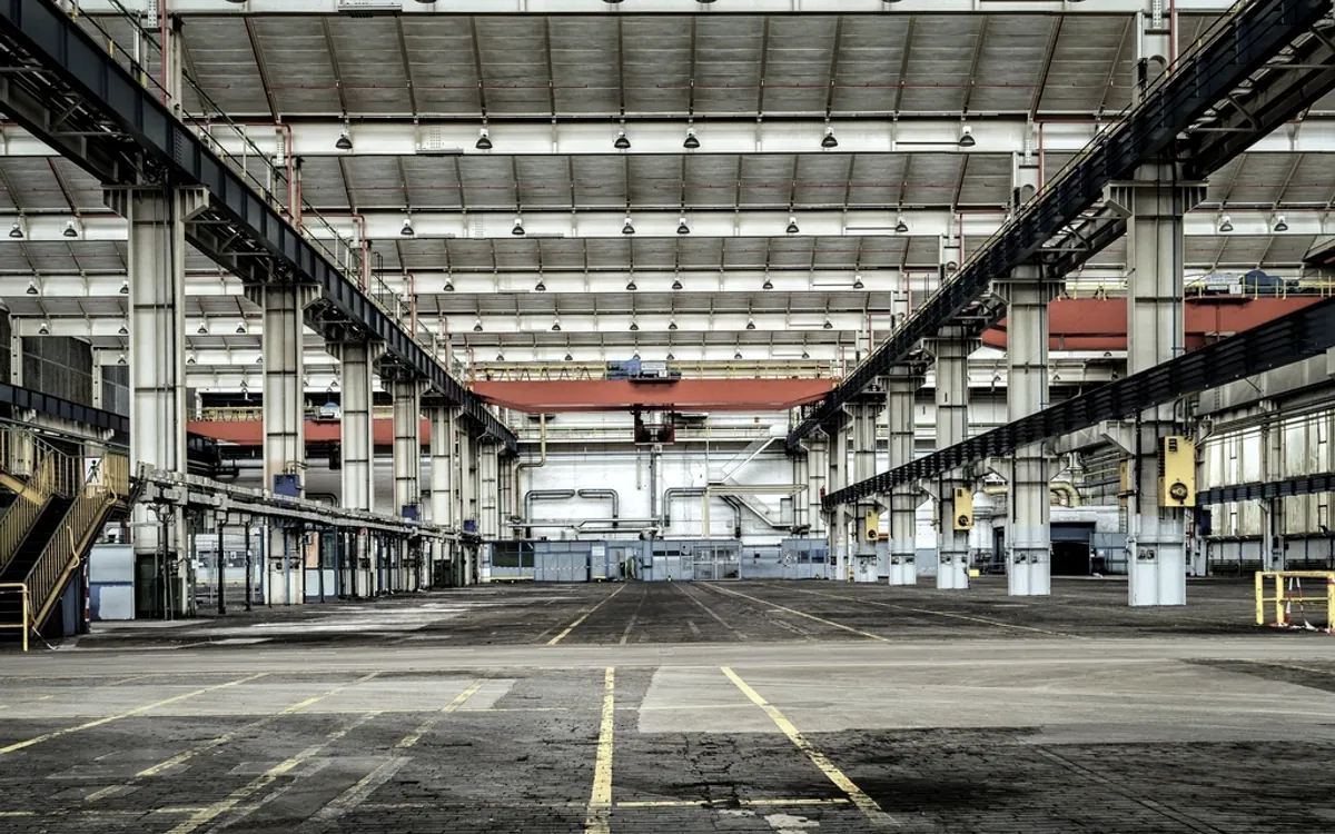 Entrepôt logistique aux volumes ordonnés, évoquant l’harmonisation d’activités réparties sur plusieurs sites