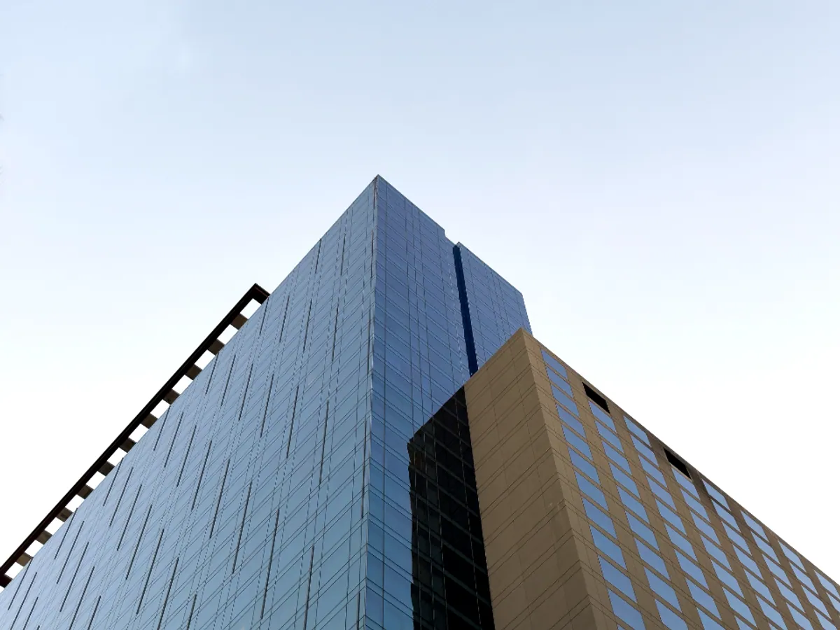 An office building seen from the street, a corner of glass and stone against the sky